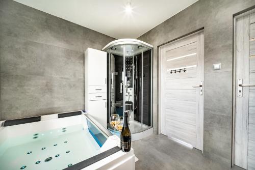 科沃布热格Domek hot tub jacuzzi Chillout的大型浴室设有浴缸和淋浴。