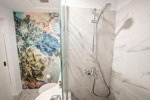 苏恰瓦MyContinental Suceava的浴室设有马赛克墙和淋浴。