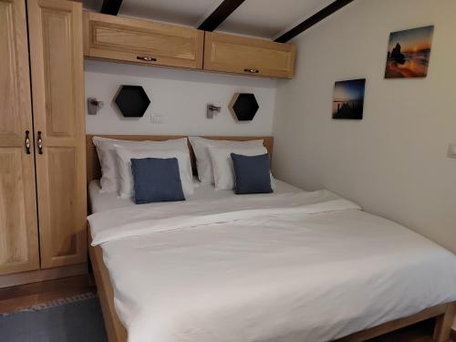 罗维尼Relax green house的卧室配有带蓝色枕头的大型白色床