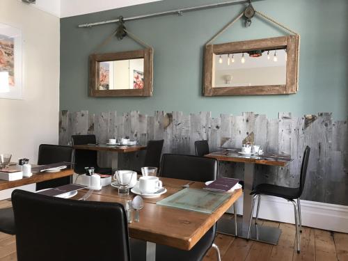 纽基圣伯纳德酒店的用餐室配有木桌、椅子和镜子