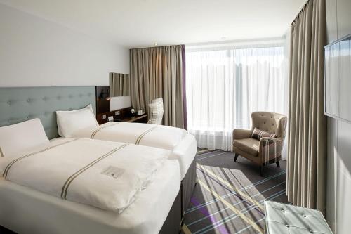 汉堡Premier Inn Hamburg City Zentrum的酒店客房,配有两张床和椅子