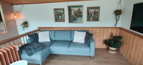 SandavágurThe Kontor的客厅配有蓝色椅子和墙上的照片