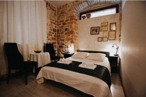 斯普利特Borna and Franko Rooms Split city centre的一间卧室设有一张床和砖墙