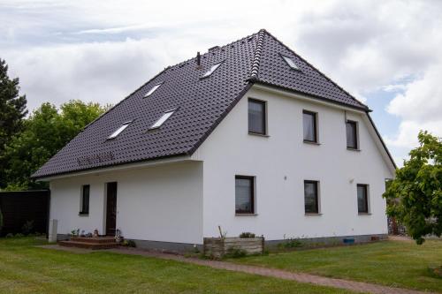 维克Urlaubs-Appartement am Dorfrand的黑色屋顶的白色房子