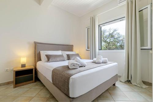 Agia Pelagia ChlomouGialos Holiday House的一间卧室配有一张大床和毛巾