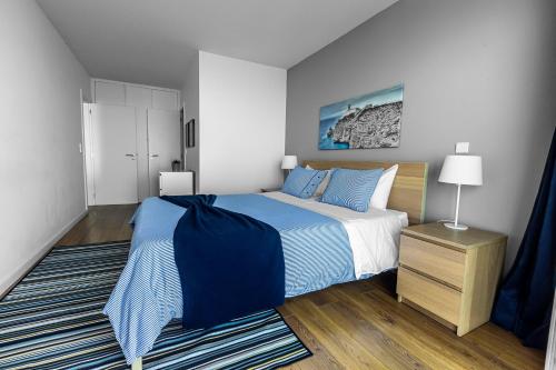 马普托Xenon Urban Apartments的卧室配有蓝色和白色的床和地毯。