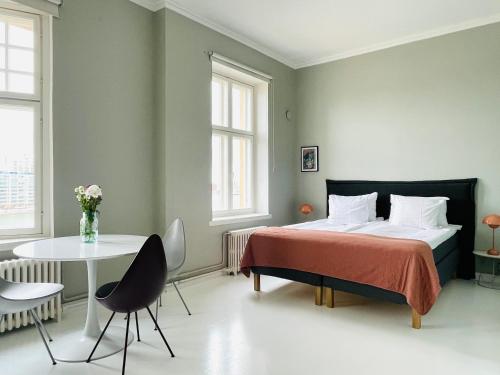 赫尔辛基Kruna by the Sea的卧室配有一张床和一张桌子及椅子