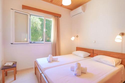 MagaziáIsabella Paxos Holidays的一间卧室设有两张床和窗户。