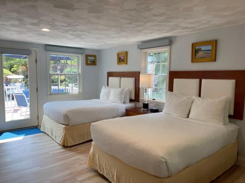 查塔姆宜人海湾村度假酒店的酒店客房设有两张床和一个阳台。