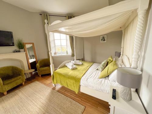 班伯里Castle At Edgehill的一间卧室配有一张带黄床罩的天蓬床
