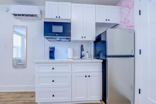加尔维斯敦Pink Flamingo Studio Apartment的厨房配有白色橱柜和冰箱。