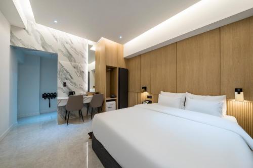 木浦市Brown Dot Hotel Pyeonghwa plaza的卧室配有一张白色大床和一张书桌