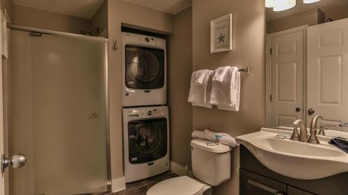 德斯坦Majestic Sun 1006B的浴室配有洗衣机、洗衣机和烘干机。