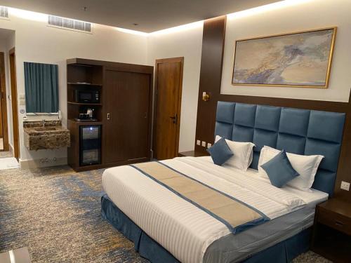 利雅德فايف بالم الفندقية的一间卧室配有一张大床和蓝色床头板