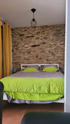 波尔尼克Au cœur de Pornic的一间卧室配有一张绿色的砖墙床