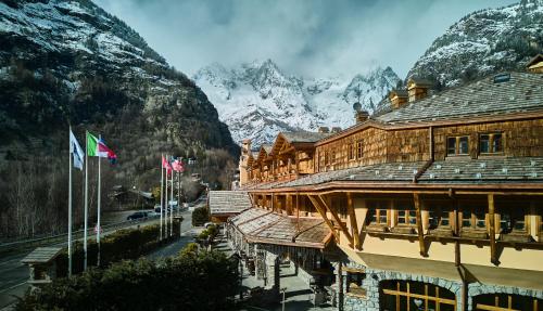 库马约尔iH Hotels Courmayeur Mont Blanc的一组背景为山脉的建筑