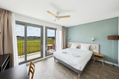 拉特斯特德布赫拉特斯特全套房酒店 - 阿卡雄湾的一间卧室配有一张床铺和一张桌子,并设有一个阳台