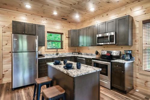 赛维尔维尔Entire cabin in Sevierville, Tennessee的厨房配有不锈钢用具和木墙