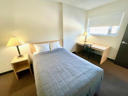 渥太华酒店及会议中心 - 渥太华市区的配有一张床、一张书桌和一扇窗户的酒店客房