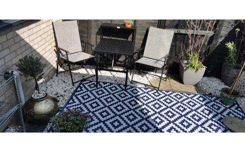 圣艾夫斯The Big Slepe的地毯上设有带两把椅子和一张桌子的庭院