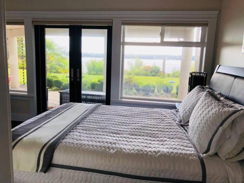 SaanichtonSaanichton Waterfront 2BR suite with superb views的一间卧室设有一张大床和两个窗户