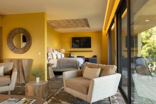 韦基奥圣露西港口Les Regalia Hôtel & Spa的一间客厅,拥有黄色的墙壁和一间卧室