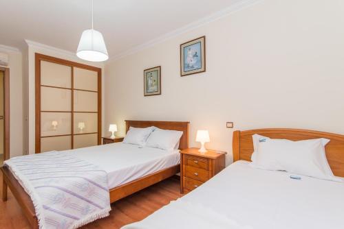 塔维拉Casa Mergoux - Maravilhoso Apartamento em Tavira的一间卧室设有两张床和两个床头柜