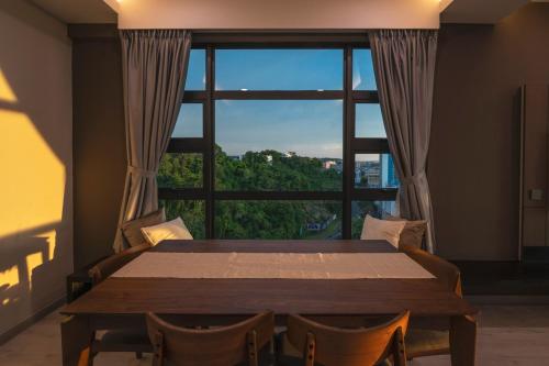 哥打京那巴鲁Bornean Milieu @ JQ Kota Kinabalu的一间带桌子和大窗户的用餐室