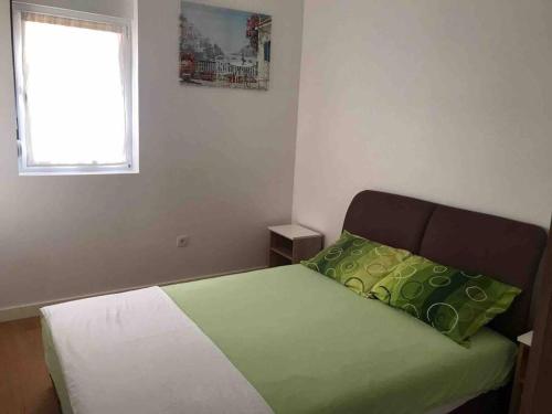 比耶拉New Comfortable Apartment in Bijela - Appart numéro 2的一间卧室配有一张带绿色和白色床单的床,并设有窗户。