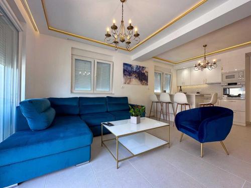 蒂瓦特Apartments Infinity的客厅配有蓝色的沙发和桌子