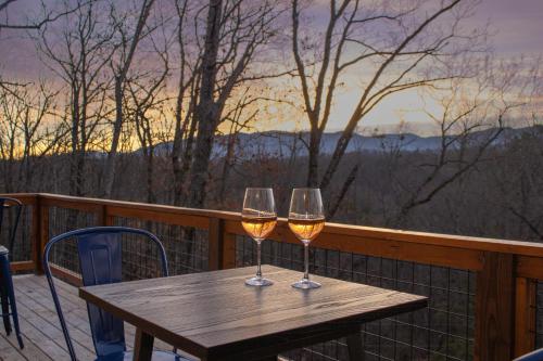 赛维尔维尔Entire cabin in Sevierville, Tennessee的阳台上的木桌旁摆放着两杯葡萄酒