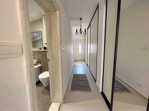 蒂瓦特Apartments Infinity的走廊通往带卫生间的浴室