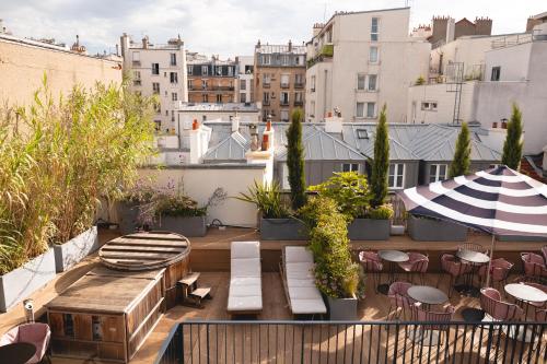 巴黎Hôtel Wallace - Orso Hotels的屋顶露台配有桌椅和遮阳伞。