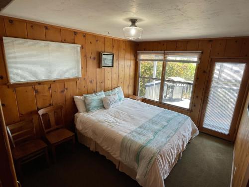 阿维拉海滩141 A 1st Street的卧室配有一张床铺,位于带木墙的房间内