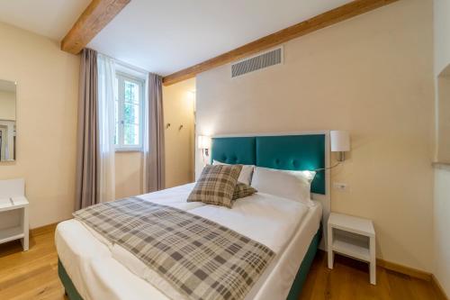科莱基奥Al Torrione的一间卧室配有一张大床和绿色床头板
