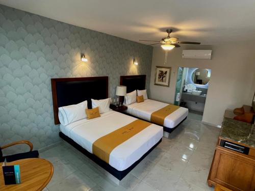 库利亚坎Hotel Maioris Bellavista的酒店客房设有两张床和一张桌子。
