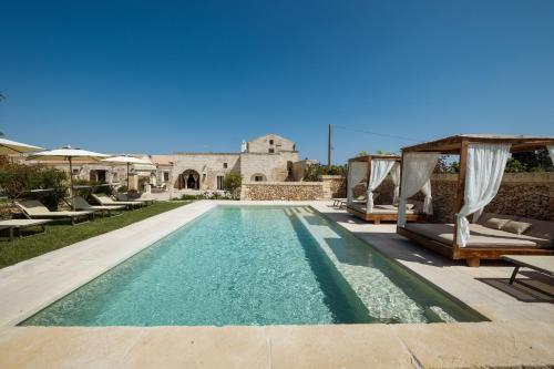 博尔加涅Agriturismo Masseria Costarella的一个带椅子的游泳池以及一座房子