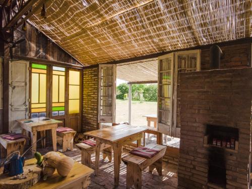 科洛尼亚-德尔萨克拉门托Caliu Earthship Ecolodge的客房设有木桌和砖砌壁炉。