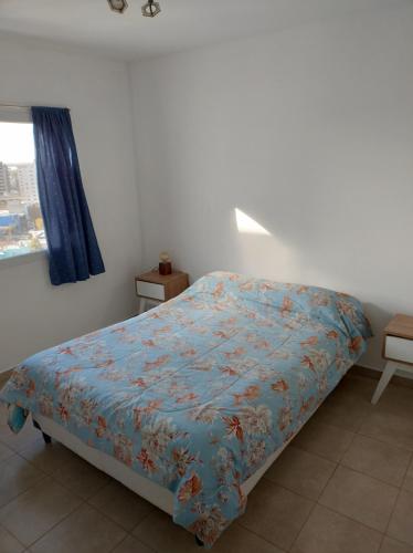 特雷利乌Vistas Meseta Patagónica II的一间卧室配有一张带蓝色棉被的床和窗户。