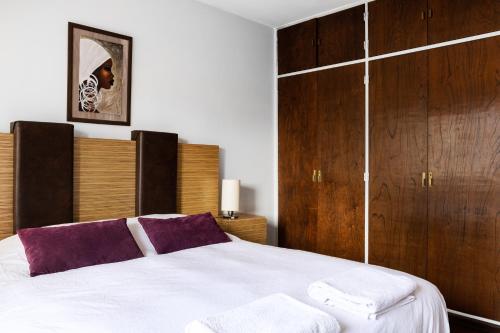 圣卡洛斯-德巴里洛切Piso villegas的卧室配有一张白色大床和木制橱柜。