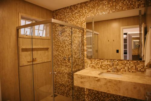 卡皮托利乌Engenho da Serra Hotel EcoResort的带淋浴、盥洗盆和镜子的浴室