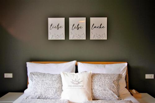 阿特湖畔翁特拉赫Apartment Ferienwohnung DAS UNTERACH am Attersee的床上方墙上的三张照片,配有四个枕头