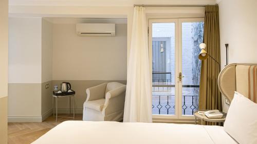 伊斯坦布尔Ishak Pasa Palace by Signature Hotels的卧室配有床、椅子和窗户。