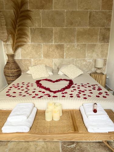 马里尼亚讷Romance en Provence的一间卧室配有一张带毛巾的床和一张带床的桌子