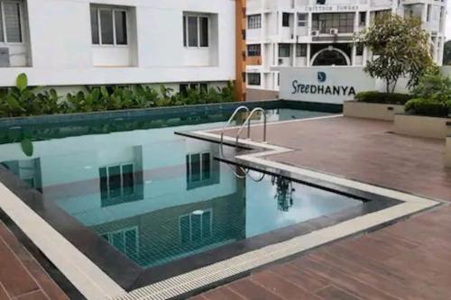 特里凡得琅Luxurious Apartment with a pool and gym near Trivandrum railway station的一座大楼中央的游泳池
