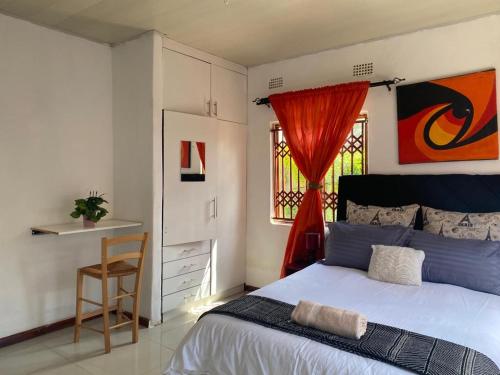 卢萨卡Samkab Legacy & comfort Ndeke (airport)的卧室配有床、椅子和窗户。
