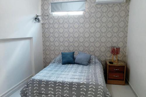 圣多明各Malecon Rooms y Hotel的一间卧室配有一张带蓝色枕头的床。