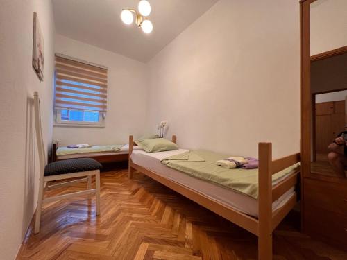 莫斯塔尔DALIA Apartment & Room的带窗户的客房内设有两张单人床。
