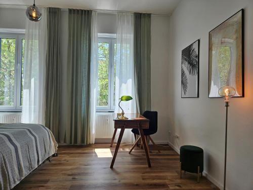 普福尔茨海姆Innenstadt Studio的卧室配有一张床、一张书桌和窗户。