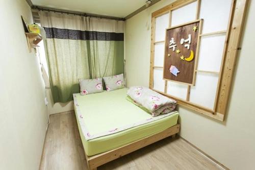 全州市Danaharu Guesthouse的窗户客房内的小床